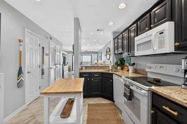 a kitchen with stainless steel appliances granite countertop a refrigerator sink and cabinets