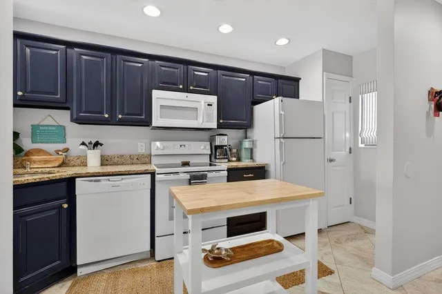 a kitchen with stainless steel appliances granite countertop a sink a stove and a refrigerator