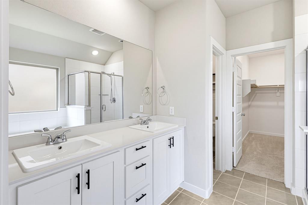 2108 Mossfield Lane Forney, TX 75126 - Photo 16 of 28 Double vanity featuring white cabinetry, quartz countertops, and undermount sinks