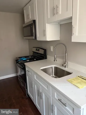 a kitchen with stainless steel appliances granite countertop a sink and a stove