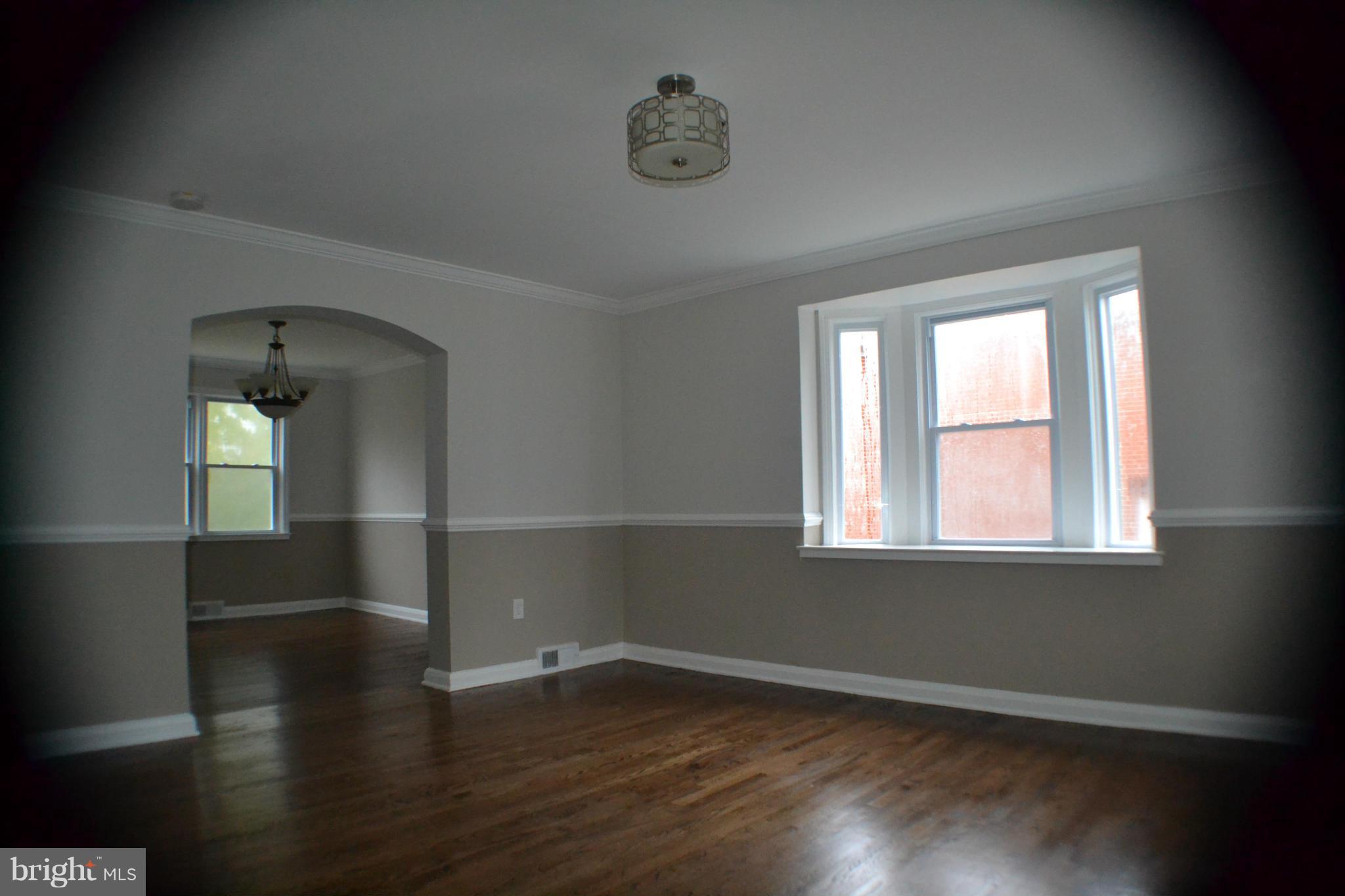 1424 Cedarcroft Road Baltimore, MD 21239 - Photo 2 of 16 an empty room with wooden floor and windows