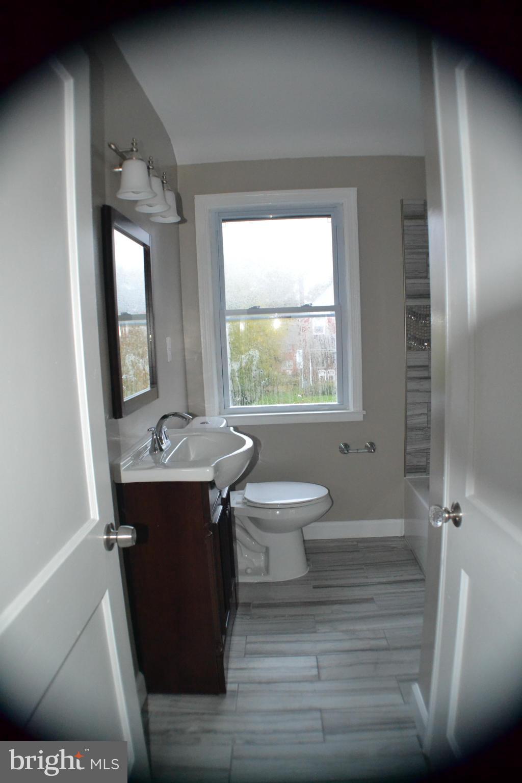 1424 Cedarcroft Road Baltimore, MD 21239 - Photo 13 of 16 a bathroom with a sink a toilet and mirror