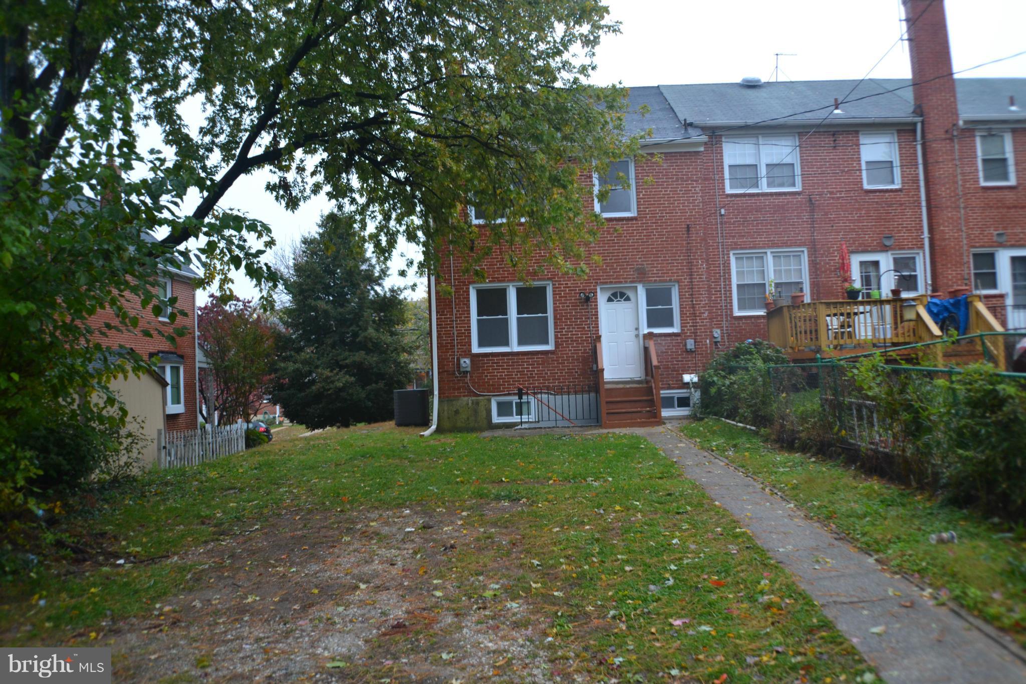 1424 Cedarcroft Road Baltimore, MD 21239 - Photo 16 of 16 a view of a brick house with a yard