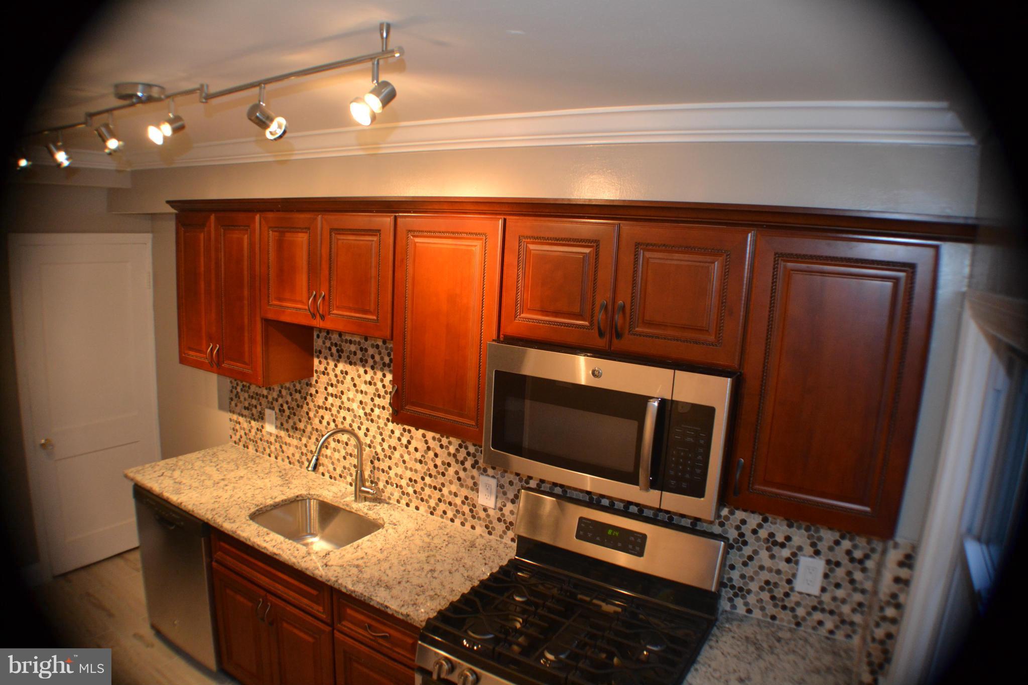 1424 Cedarcroft Road Baltimore, MD 21239 - Photo 5 of 16 a kitchen with a sink and a microwave