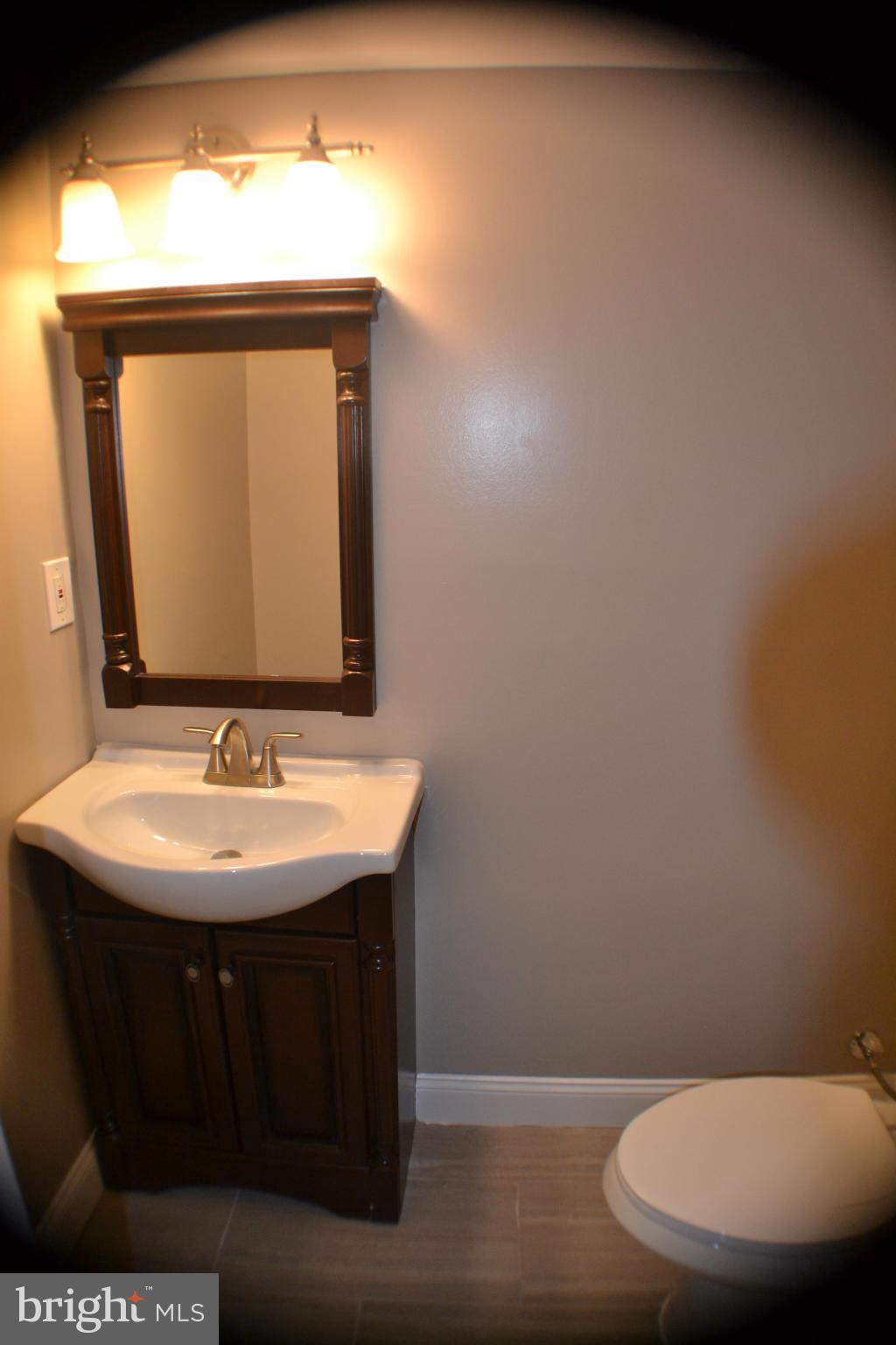 1424 Cedarcroft Road Baltimore, MD 21239 - Photo 9 of 16 a bathroom with a toilet sink and mirror