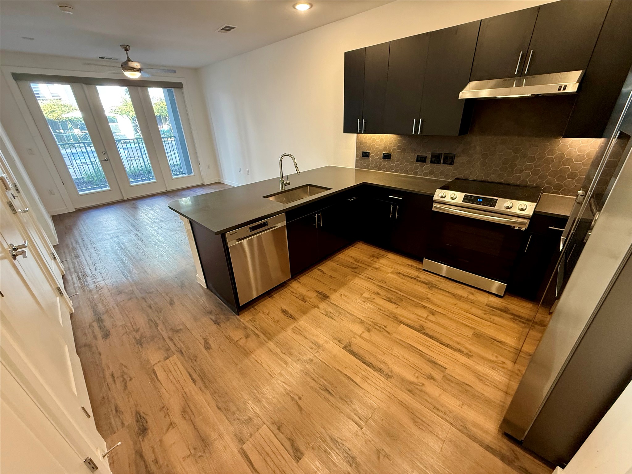 4801 Springdale Road, Unit 1106 Austin, TX 78723 - Photo 1 of 22 Gleaming wood floors anchor a modern kitchen under recessed lighting.