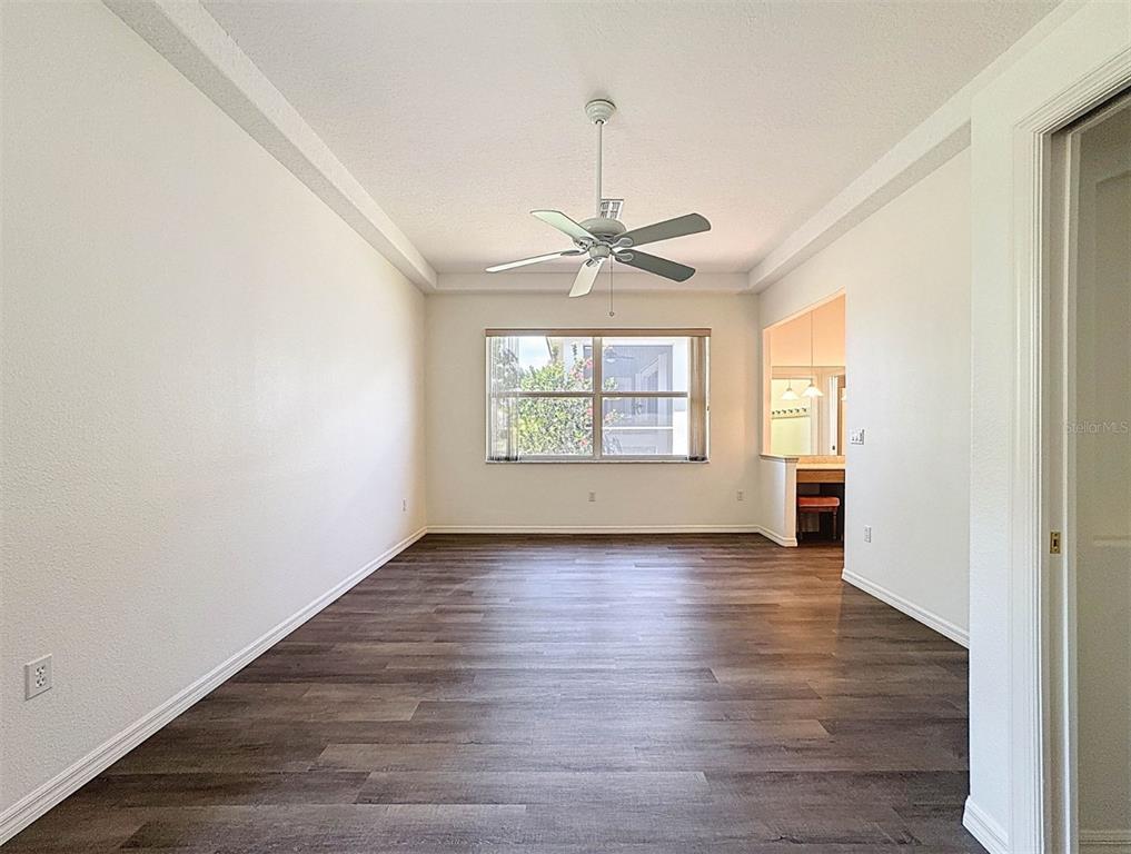 9237 Penelope Drive Weeki Wachee, FL 34613 - Photo 11 of 19 an empty room with wooden floor chandelier and windows