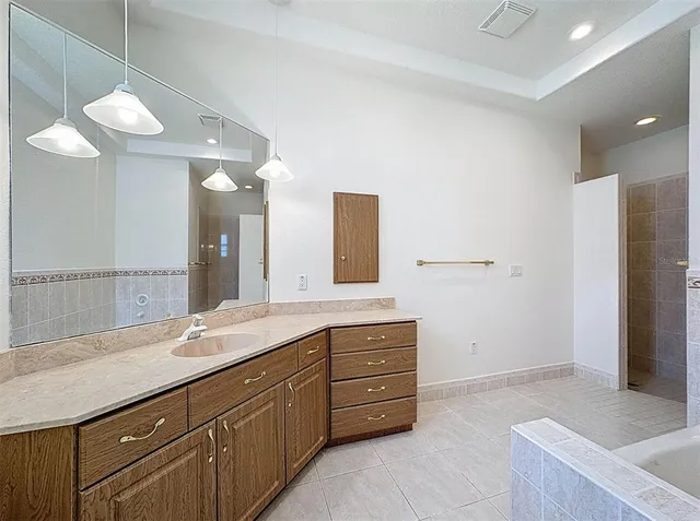 a spacious bathroom with a granite countertop sink a mirror and a shower