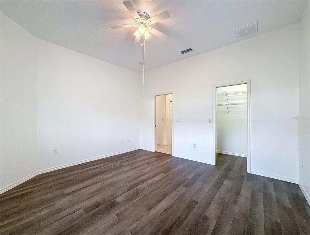 9237 Penelope Drive Weeki Wachee, FL 34613 - Photo 16 of 19 an empty room with wooden floor and fan