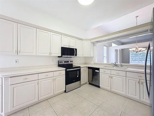 a kitchen with white cabinets stainless steel appliances and sink