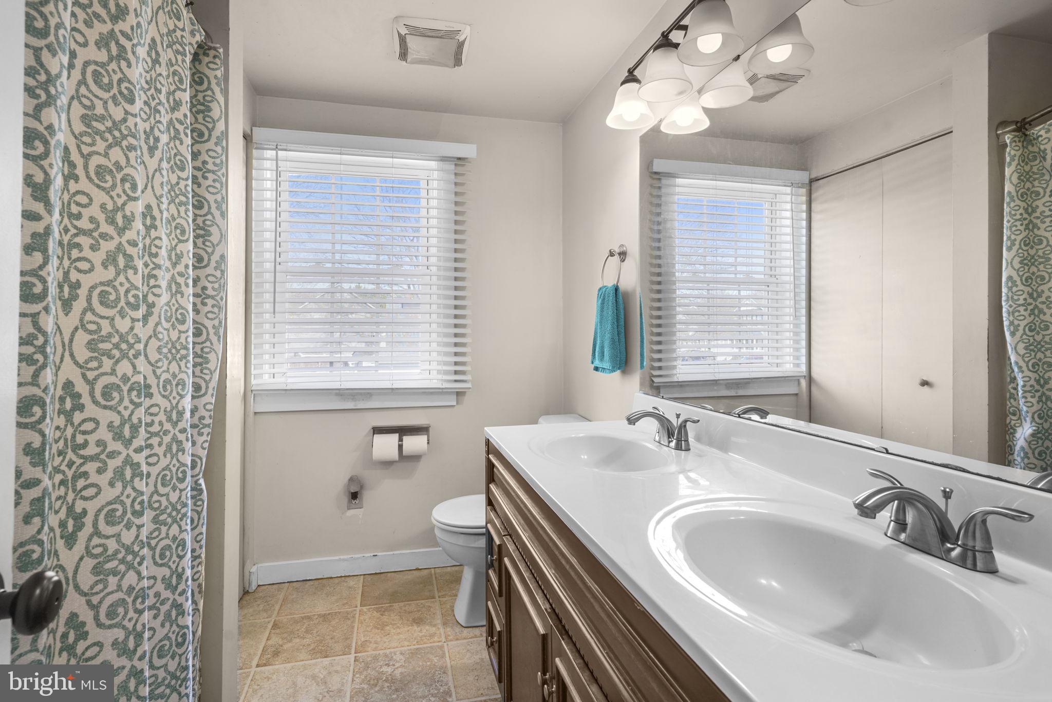 3715 5th Avenue Edgewater, MD 21037 - Photo 22 of 34 a bathroom with a sink a toilet and a large mirror