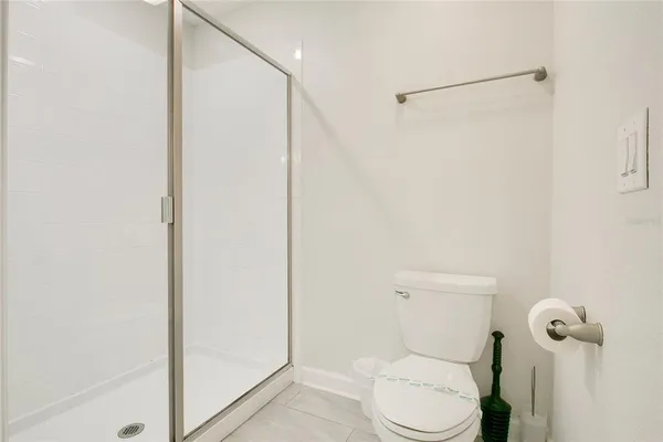 a white toilet sitting next to a shower