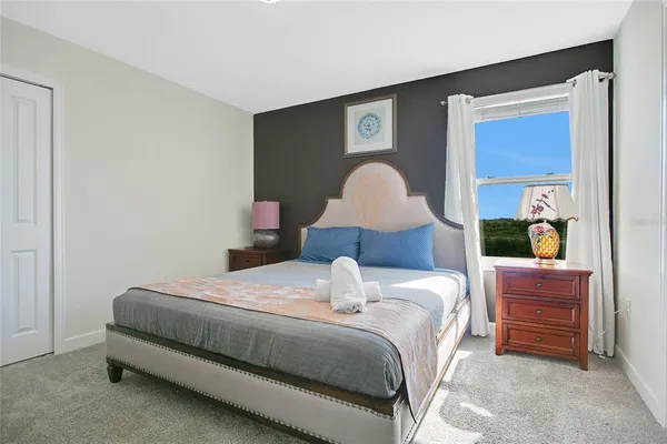 a bedroom with a bed and a lamp on dresser