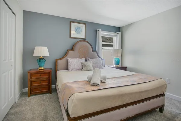 a bedroom with a bed and a lamp on dresser