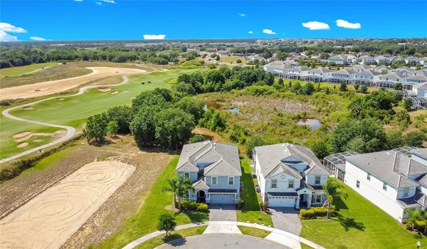 an aerial view of residential houses with outdoor space and ocean view