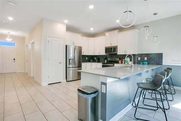 a kitchen with stainless steel appliances granite countertop a refrigerator and a stove top oven