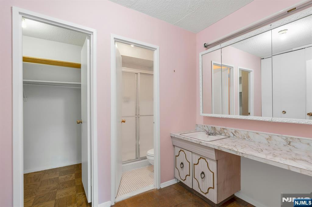 2150 Center Avenue, Unit 2E Fort Lee, NJ 07024 - Photo 18 of 34 a bathroom with a granite countertop sink and a mirror