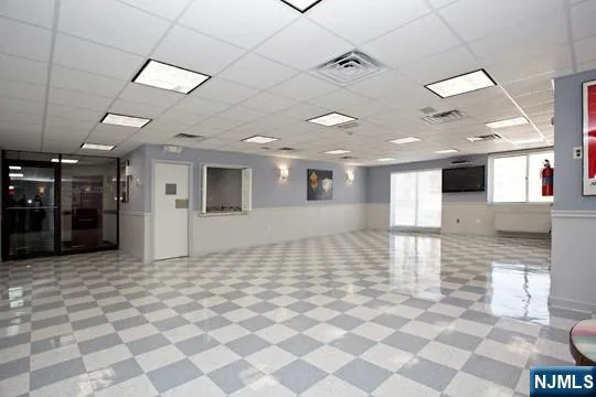 a view of a hall with a dining table chairs