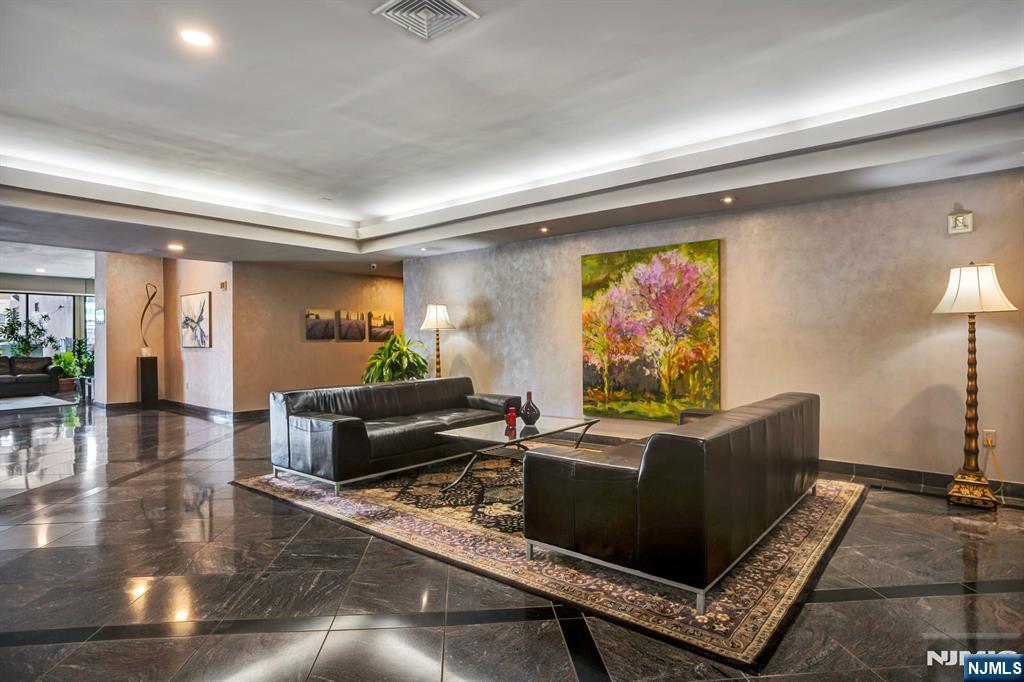 2150 Center Avenue, Unit 2E Fort Lee, NJ 07024 - Photo 31 of 34 a living room with furniture and a flat screen tv