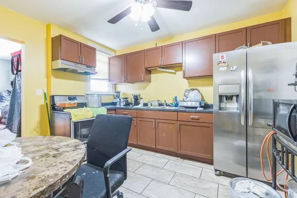 a kitchen with stainless steel appliances granite countertop a refrigerator a stove and a sink