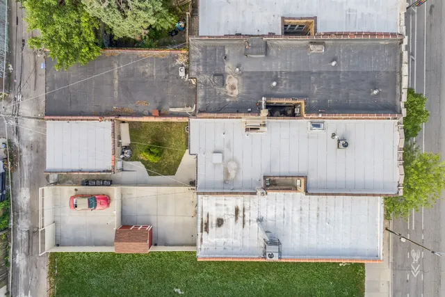 an aerial view of residential houses with outdoor space and parking