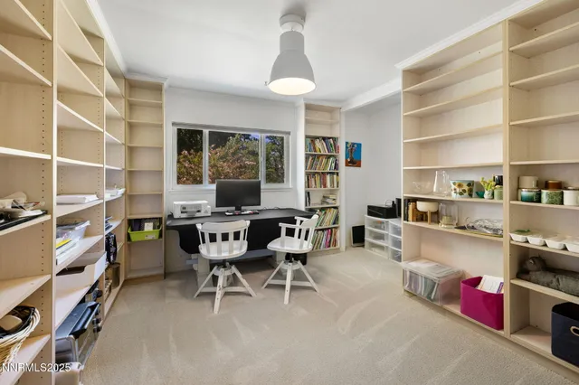 a view of a workspace with furniture and a window