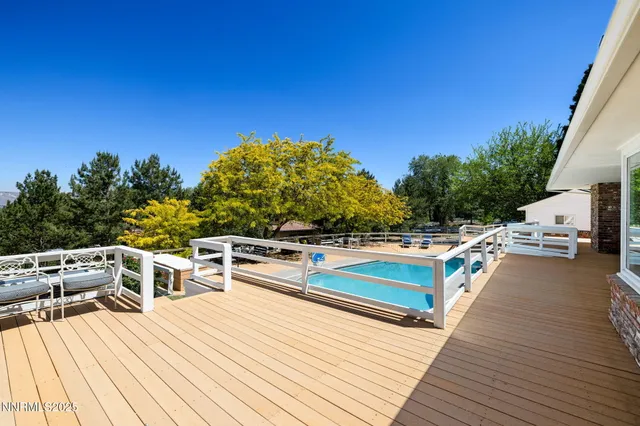 a view of a balcony with dining table and chairs