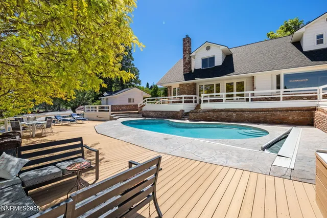 a front view of a house with swimming pool and sitting area