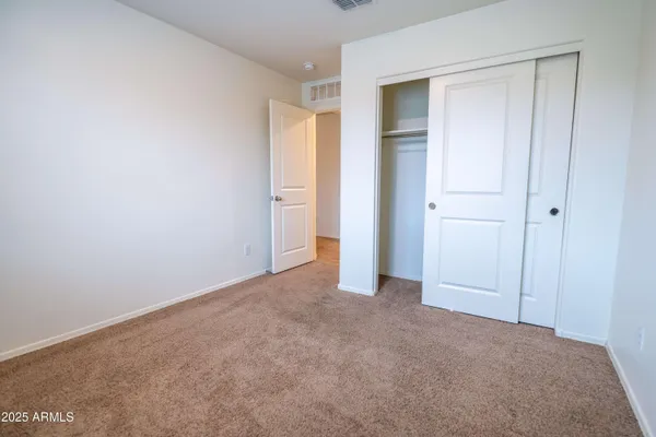 a view of an empty room and closet area