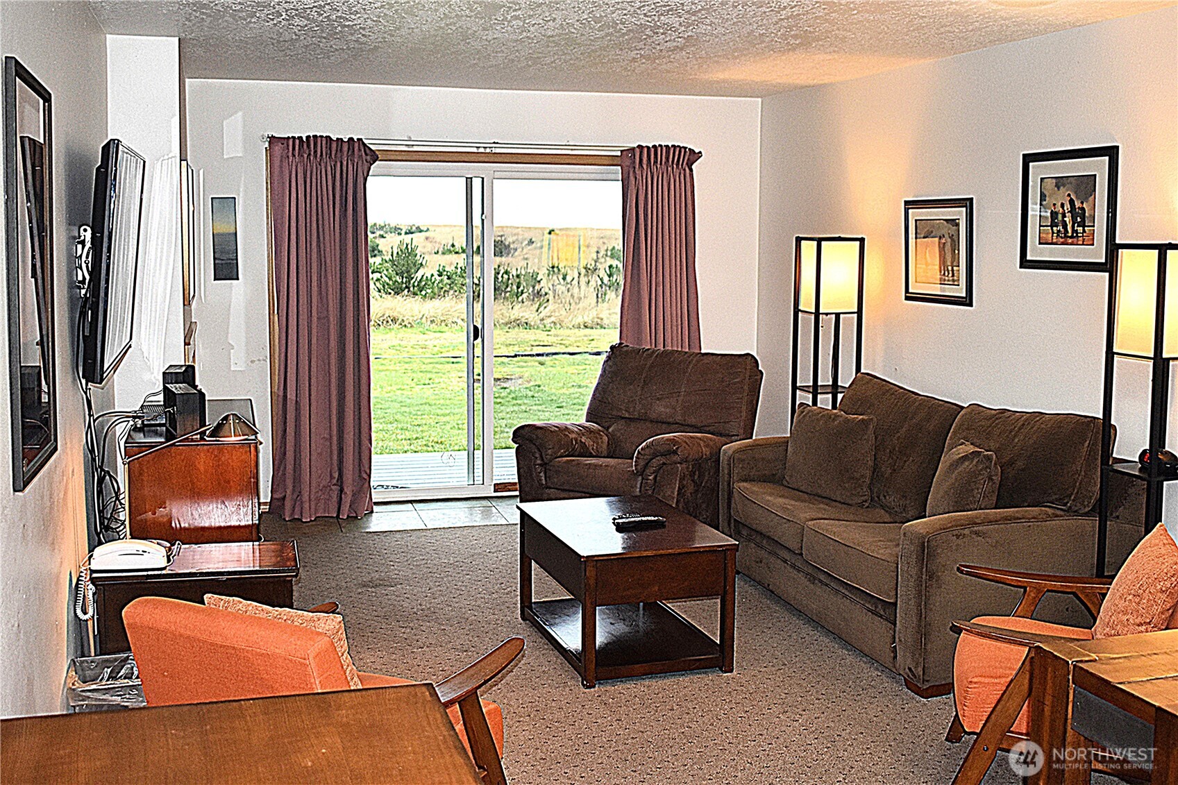 304 14th Street Northwest, Unit 115 Long Beach, WA 98631 - Photo 2 of 10 a living room with furniture a large window and a flat screen tv