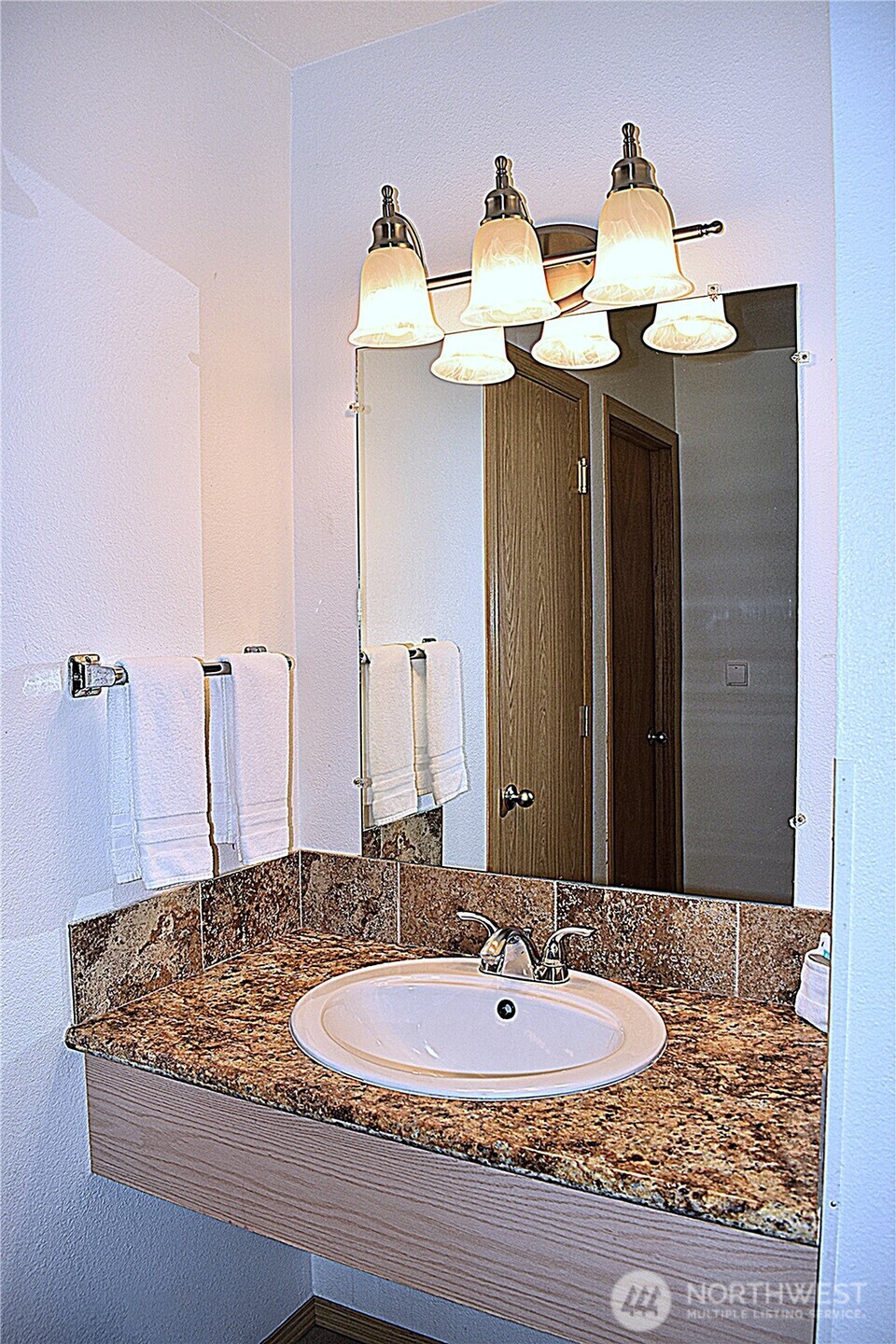 304 14th Street Northwest, Unit 115 Long Beach, WA 98631 - Photo 6 of 10 a bathroom with a granite countertop sink and a mirror