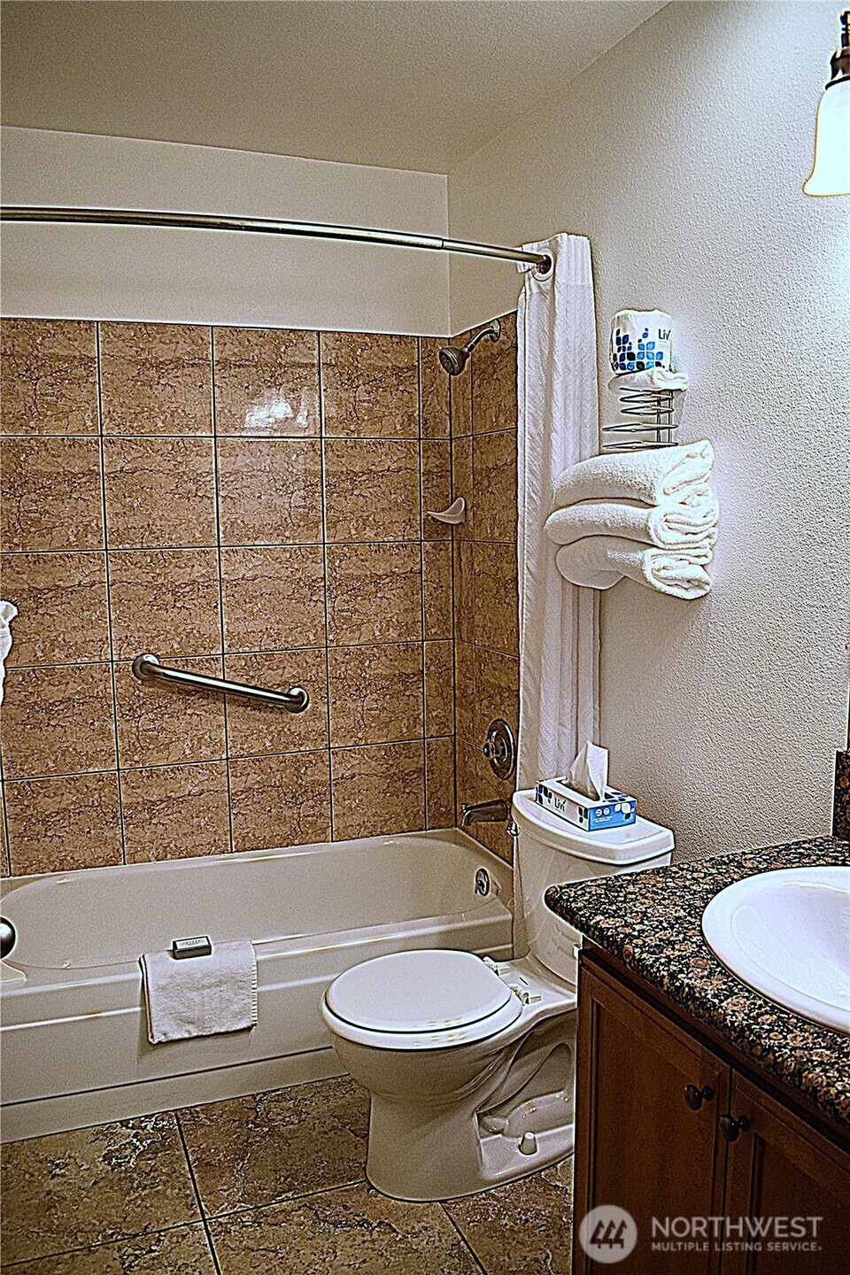 304 14th Street Northwest, Unit 115 Long Beach, WA 98631 - Photo 8 of 10 a bathroom with a granite countertop toilet sink and mirror