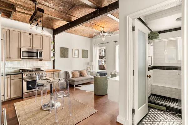 a living room with stainless steel appliances furniture and a rug