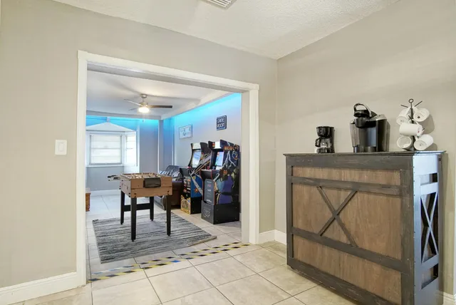 a living room with furniture a dining table and a refrigerator