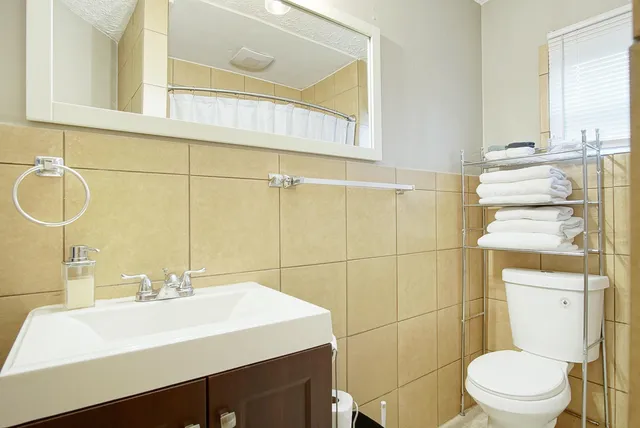 a bathroom with a sink a toilet and a mirror