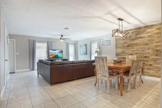 a living room with furniture a dining table and a chandelier