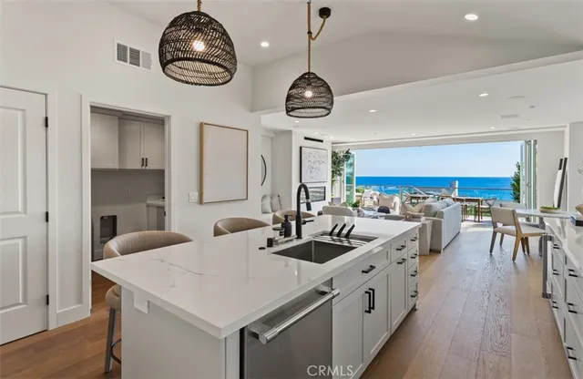 a kitchen with stainless steel appliances a large center island and a wooden floor