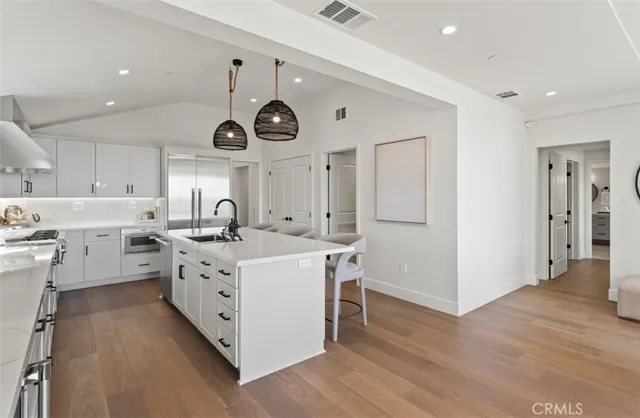 a kitchen with a stove cabinets and wooden floor