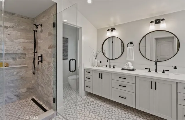 a bathroom with a double vanity sink mirror and shower