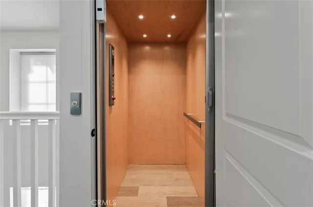 a view of a hallway with wooden floor and windows