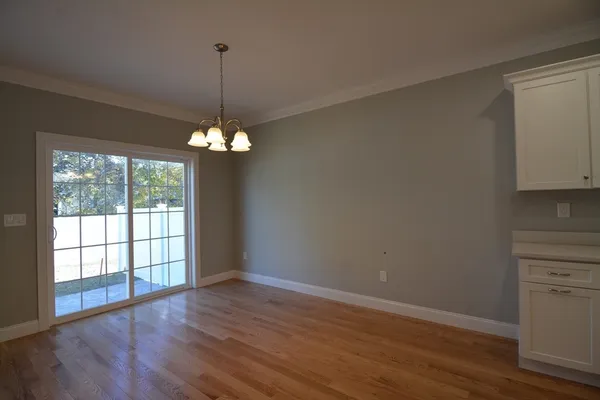 a view of a kitchen with a large window and wooden floor