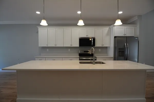 a kitchen with kitchen island a sink stainless steel appliances and a counter top space
