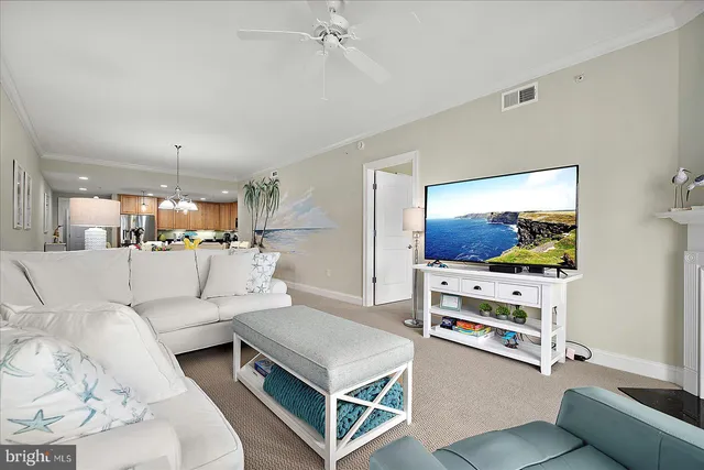 a living room with furniture and a view of kitchen