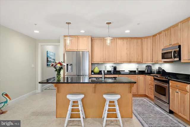 a kitchen with kitchen island granite countertop a sink and stainless steel appliances