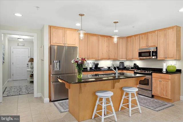 a kitchen with stainless steel appliances granite countertop a sink a stove and a wooden floors