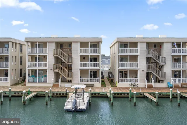 a wooden pier with boats in front of house