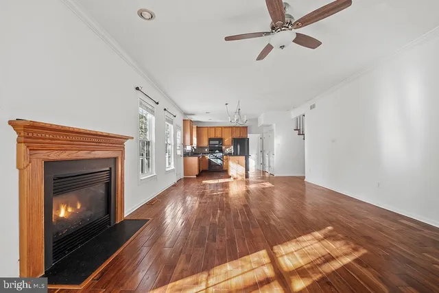 a view of a livingroom with wooden floor and a fireplace