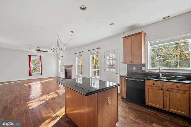 a large kitchen with kitchen island granite countertop a sink and dishwasher with wooden floor