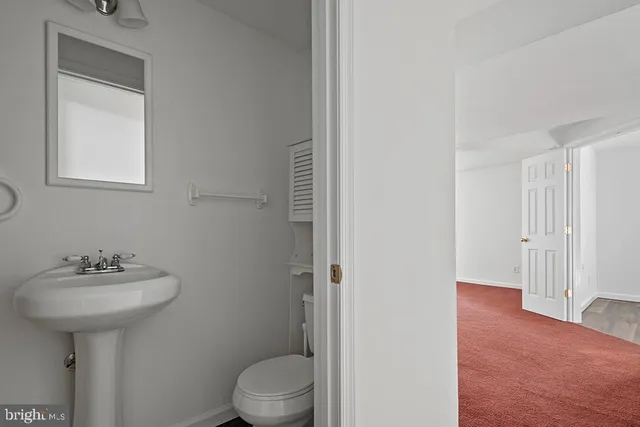 a bathroom with a sink toilet and a mirror