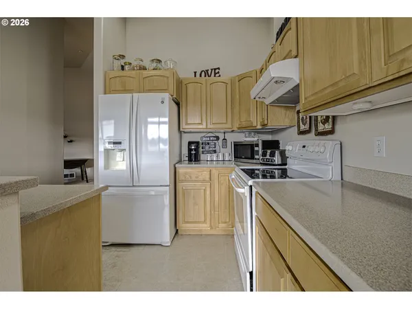 a kitchen with stainless steel appliances granite countertop a refrigerator a stove and a sink